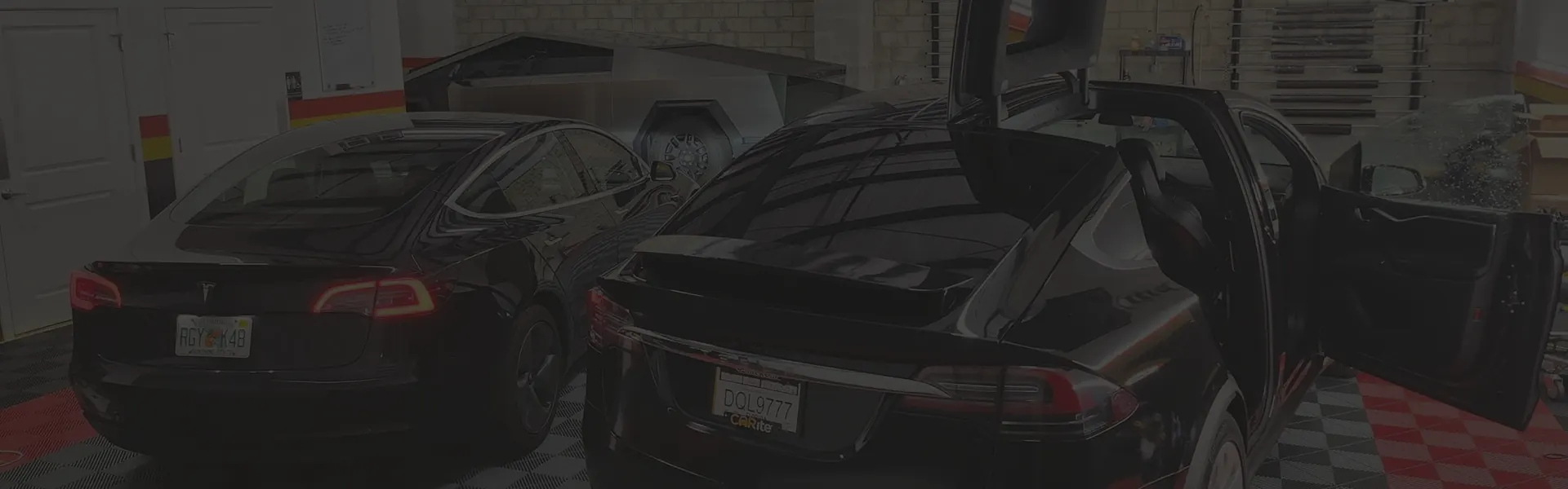 Two tinted Teslas in a Black Optix Tint bay